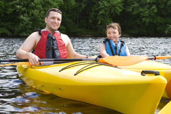 a young boy riding a boat on a body of water