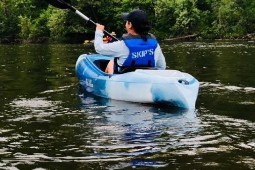 a man riding on the back of a boat in a body of water