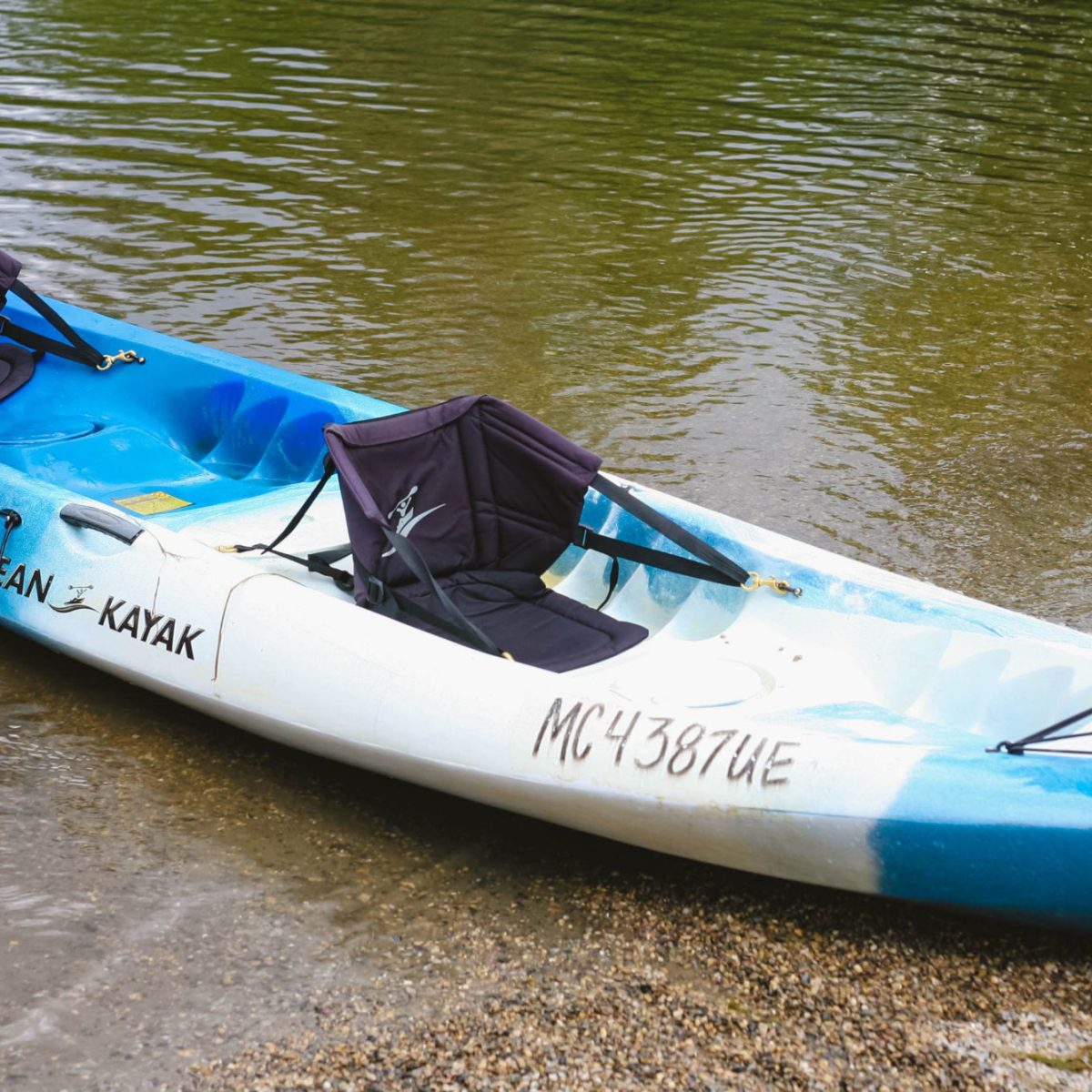 a blue and white boat sitting next to a body of water