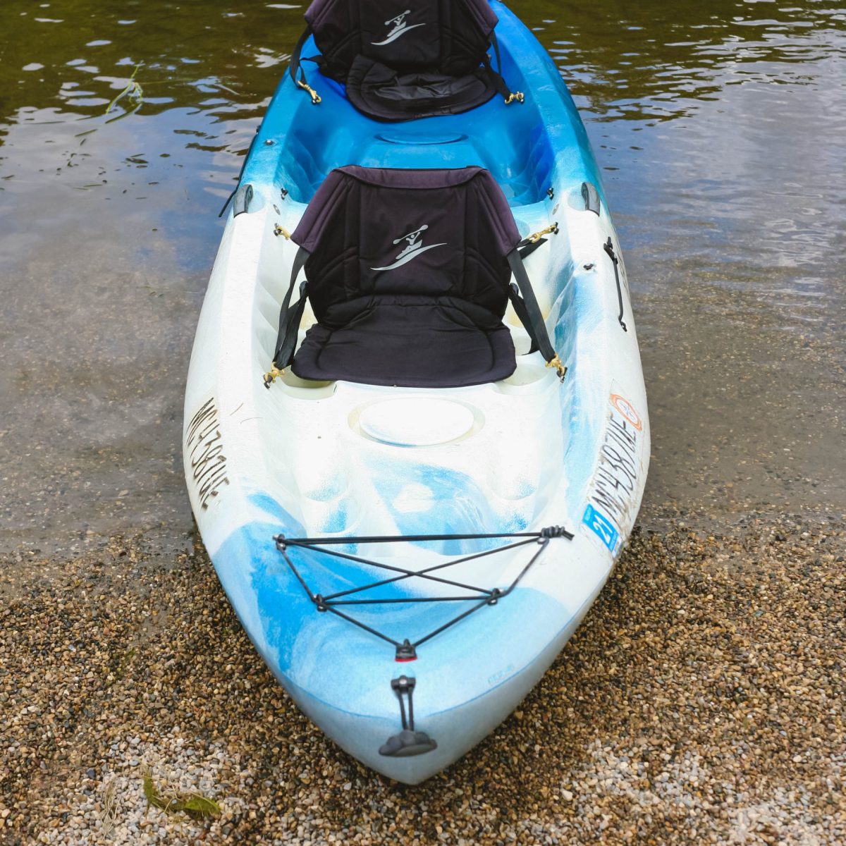 a blue and white boat sitting next to a body of water